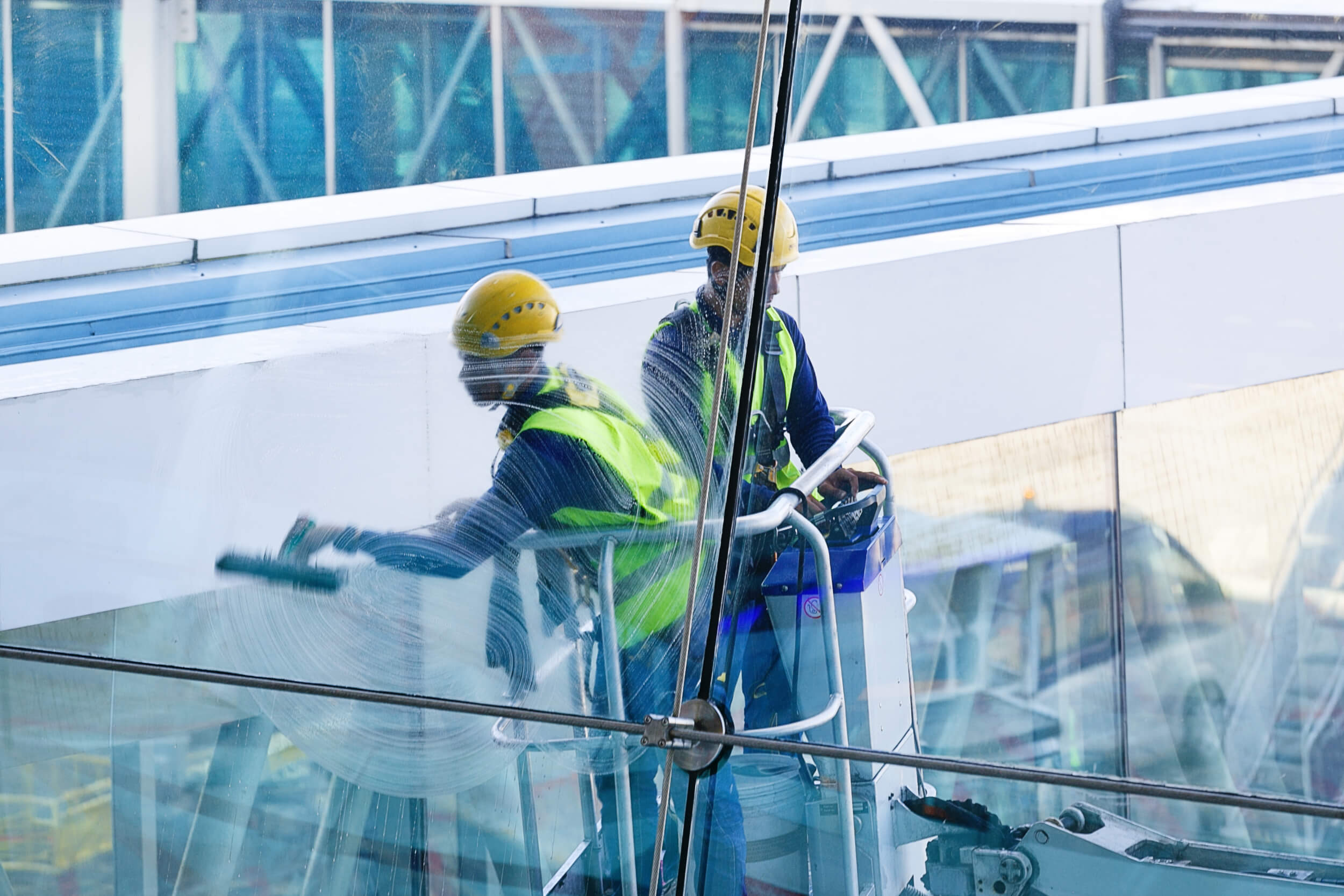 Men Cleaning Windows. Two workers washing windows of the modern business building.